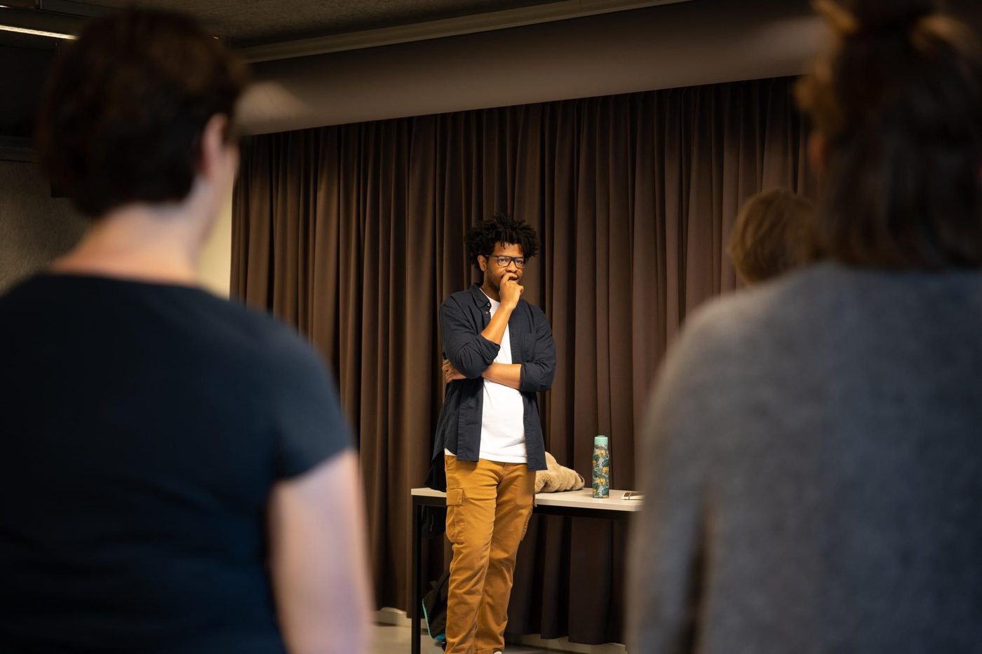 Terrance mid-thought at the front of a workshop, seen between two participants